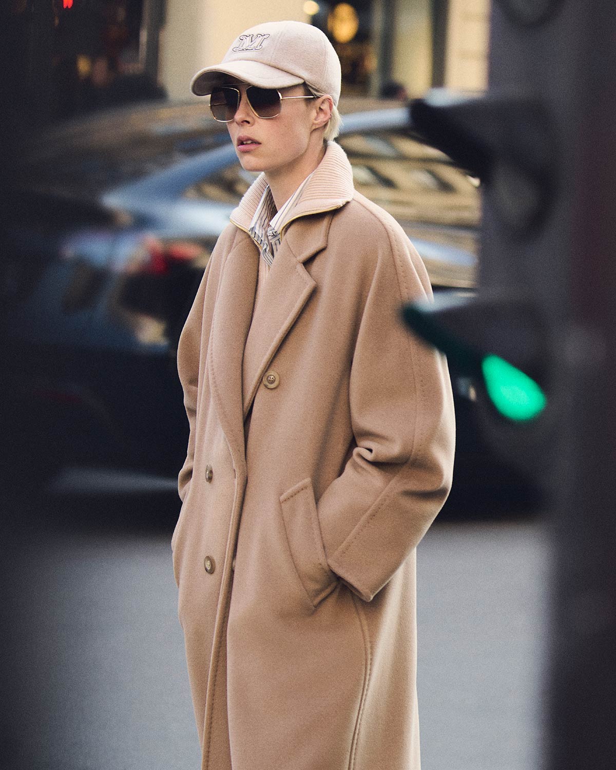 Model in Max Mara 101801 long icon coat in camel colour, paired with dark glasses and hat.